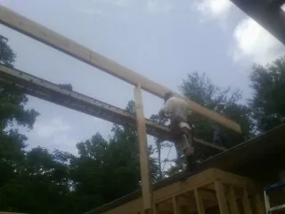 Carpenter setting a ridge beam over a new addition frame — Ice Dam Removal by Roofing Brothers in New Trenton