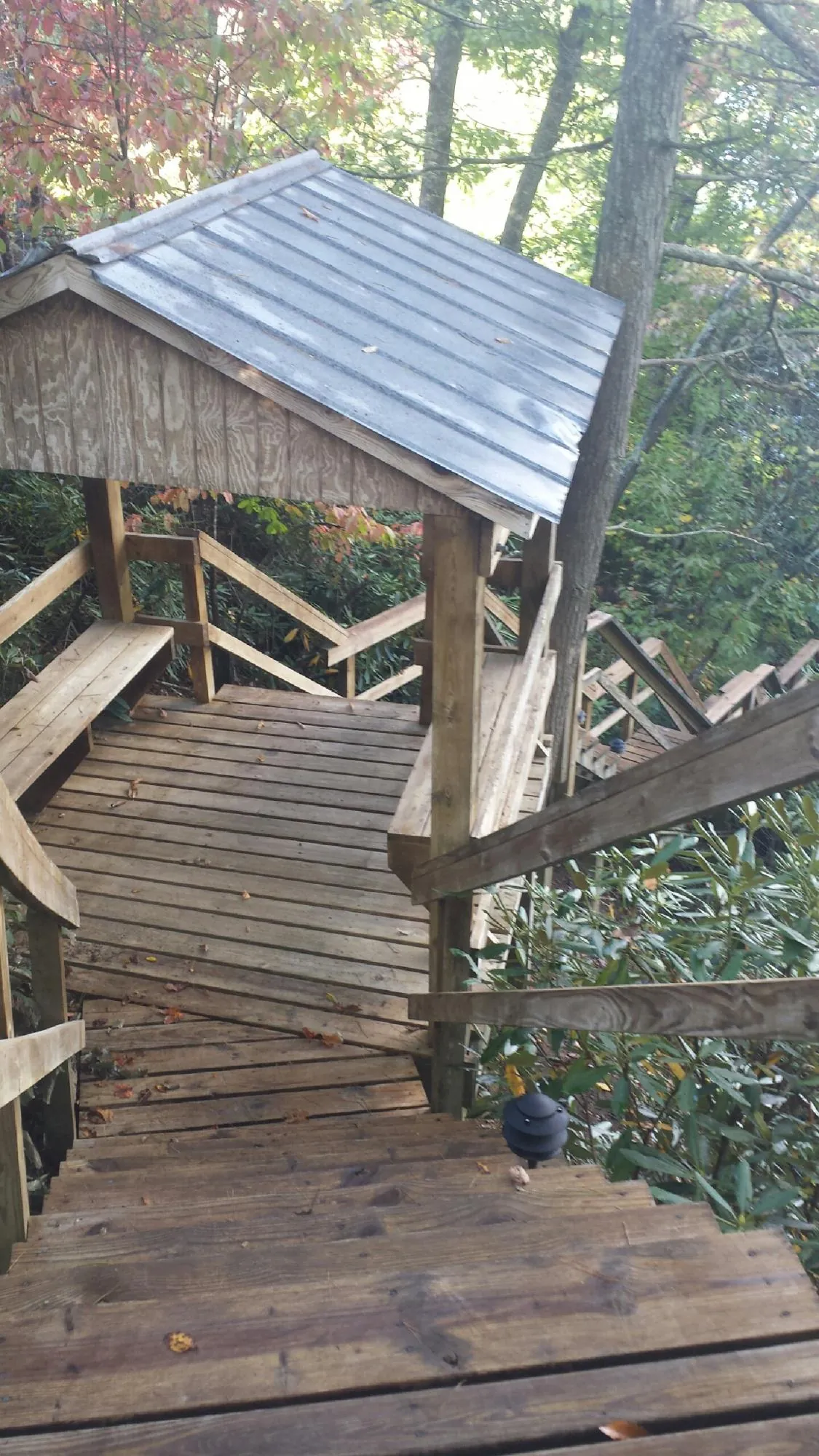 Metal roofed shelter over wooden steps on a wooded walkway — Skylight Repair & Installation work by our crew in New Trenton
