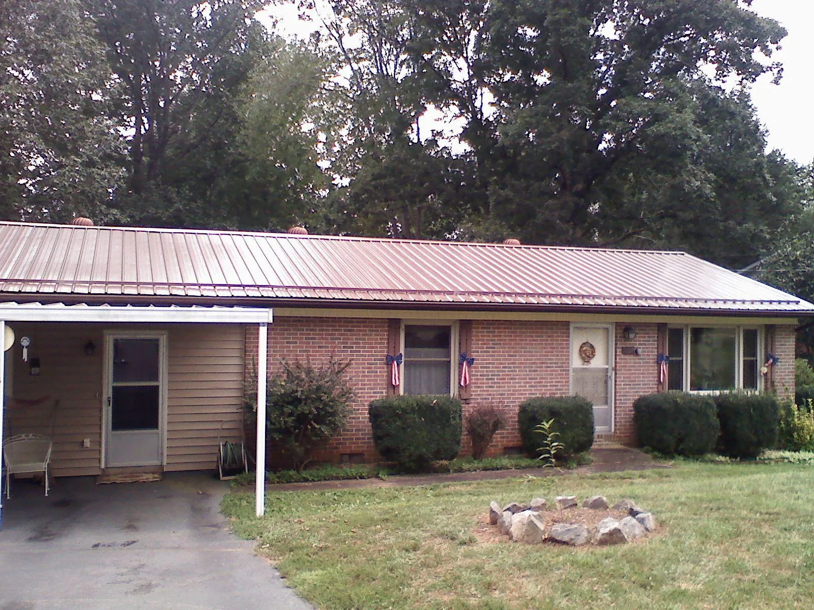Bronze metal roof and carport on a brick ranch home — Roof Repair work by our crew in New Trenton