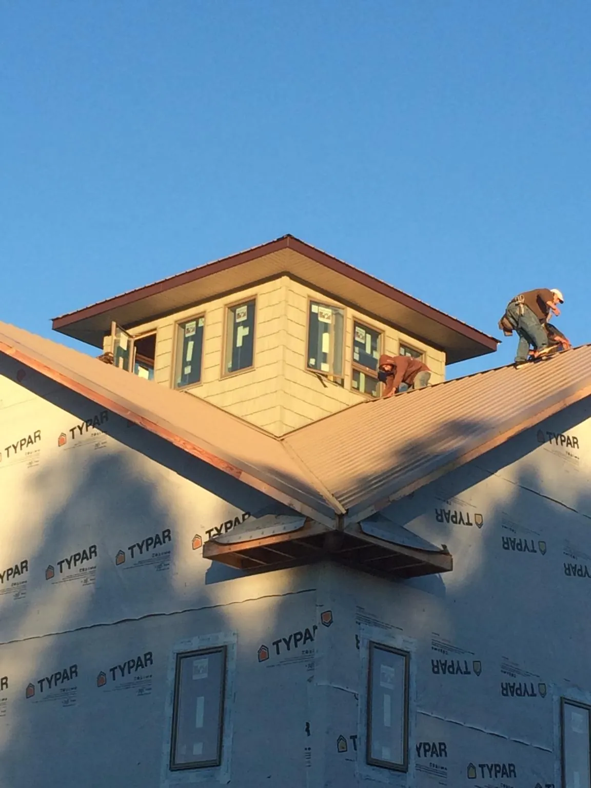Roofers working around a rooftop cupola on a new metal roof at sunset — Roof Waterproofing in New Trenton by Roofing Brothers